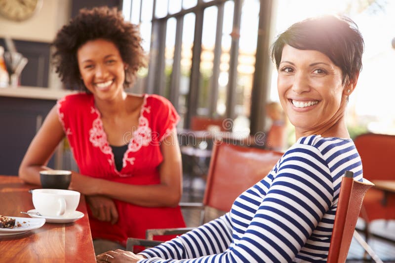 Two female friends meeting at a coffee shop