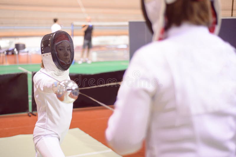 Two Fencers in White Uniforms are Training To Participate in a Duel