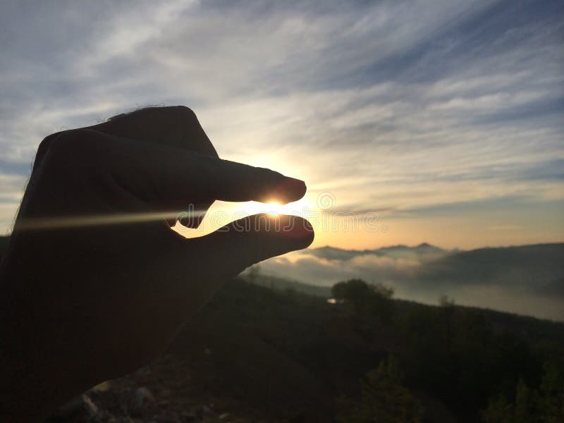 Two Fingers Holding the Sun Stock Photo Image of hill, atmosphere