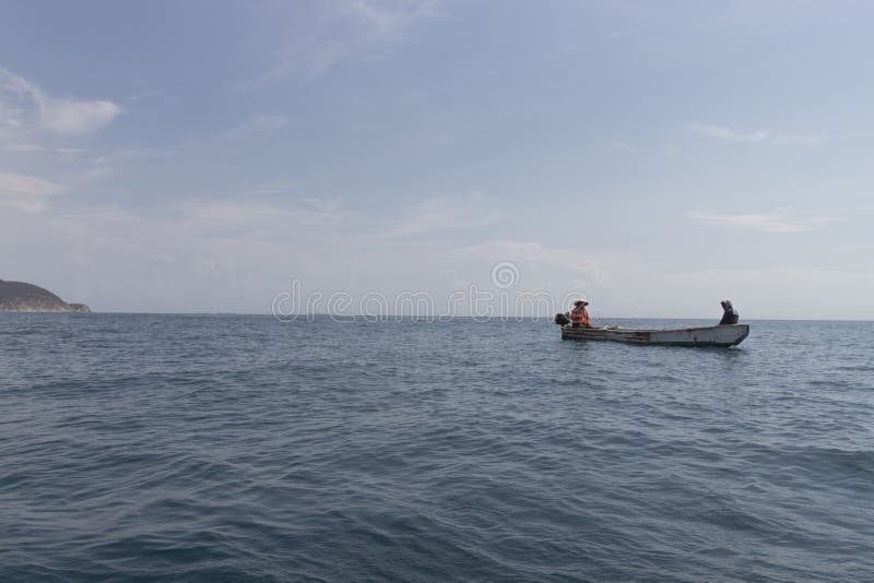 Two fisherman offshore in small boat at Santa Marta Colombia Caribbean sea in sunny day