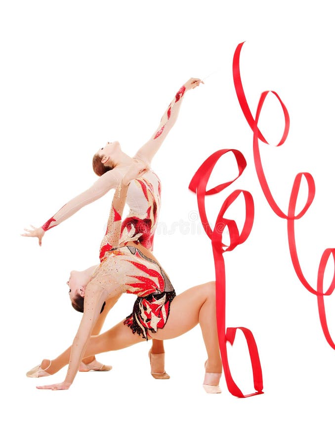 Two flexible gymnasts dancing with red ribbons royalty free stock images