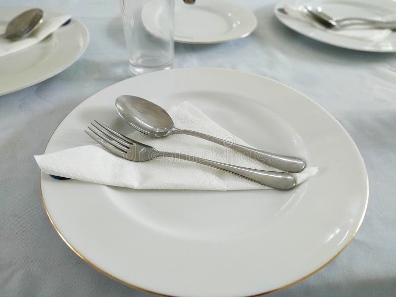 Two forks with tissue paper on a white color plate.