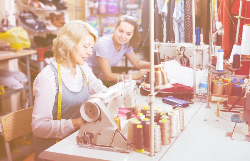 Two Friendly Women Tailors Working with Sewing Machines Stock Photo