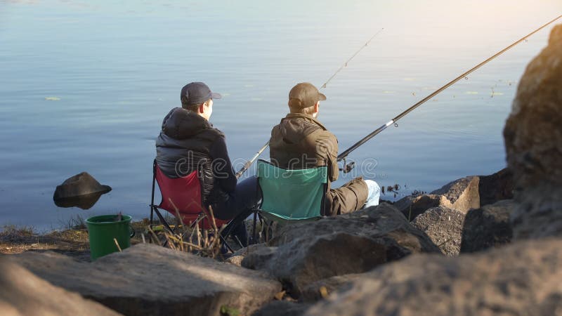 Two friends fishing to escape stressed city life, common interests, free time royalty free stock photo Two friends fishing to escape stressed city life, common interests, free time royalty free stock photo