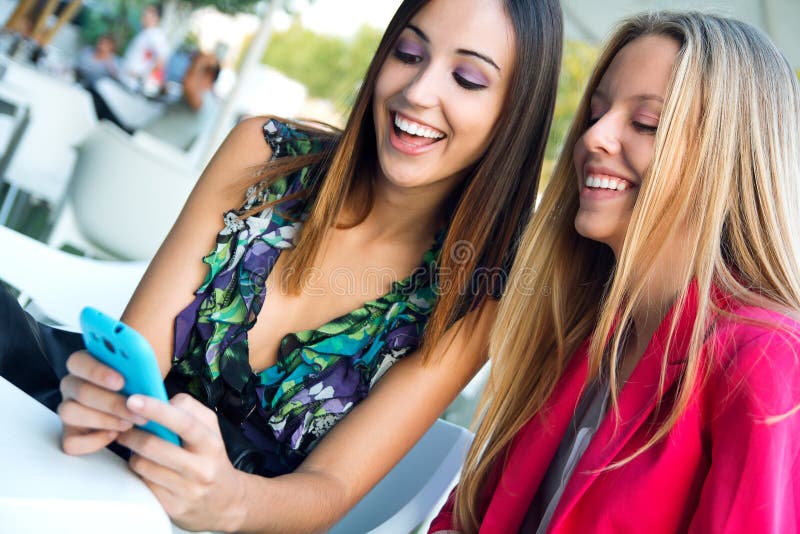 Two friends having fun with smartphones