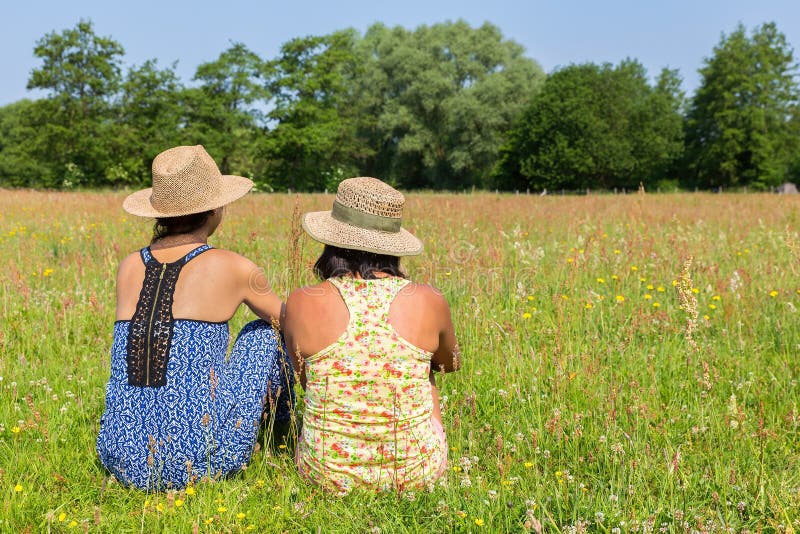 Two Friends Sitting Together In Meadow Stock Photo Image Of Happiness