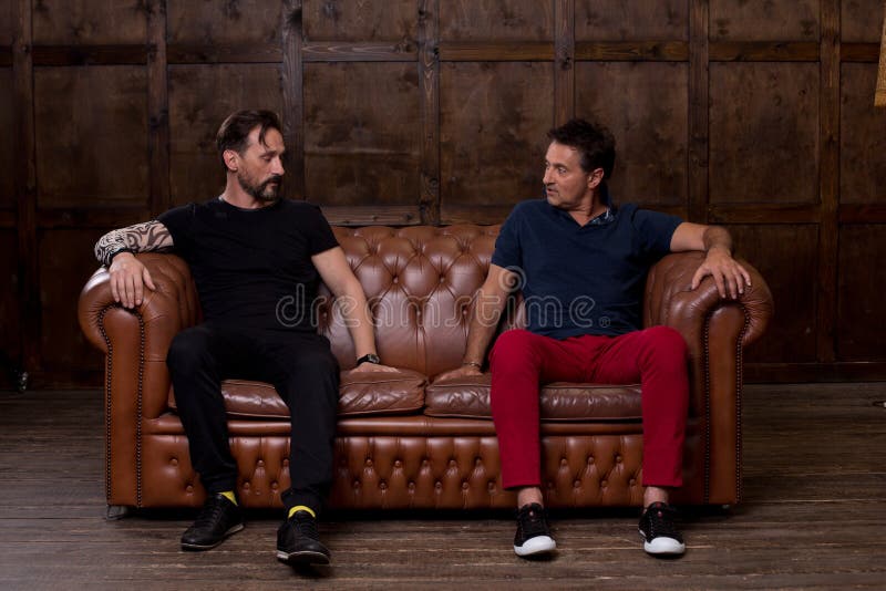 Two Friends Touching the Sofa Surface and Discussing it Stock Image