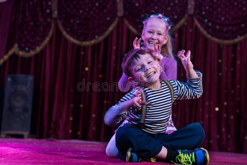 Two funny children acting as monsters on stage