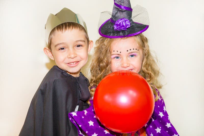 Two funny kids wearing witch and vampire costume on halloween