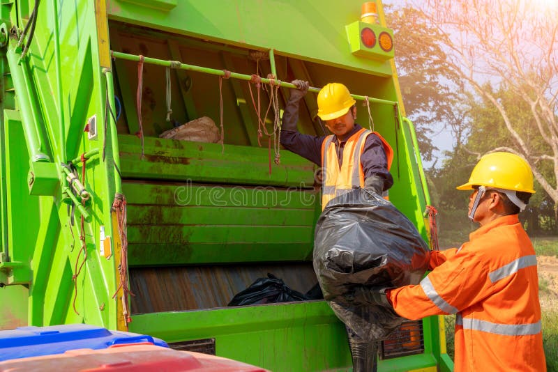 Two garbage men working together on emptying dustbins for trash removal. royalty free stock photo Two garbage men working together on emptying dustbins for trash removal. royalty free stock photo