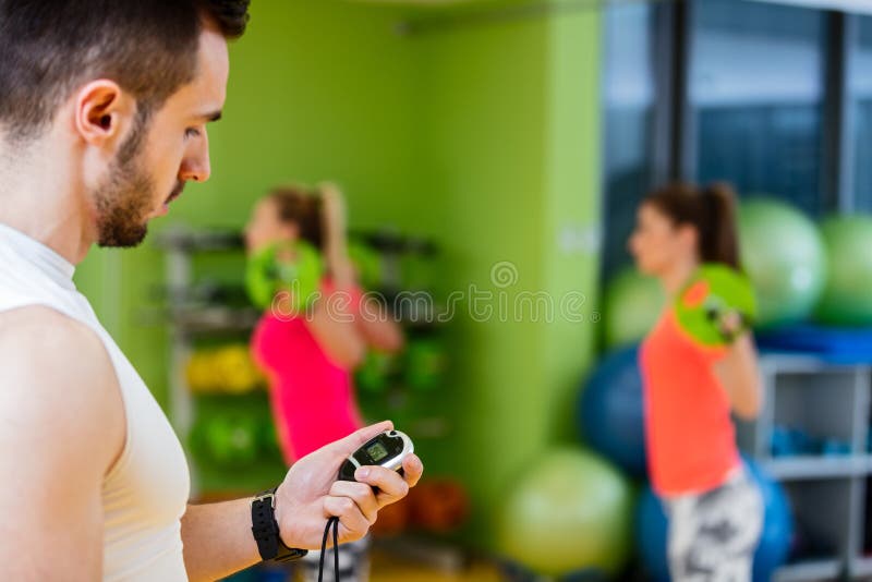 Two Girl Exercising At The Gym With A Personal Trainer Stock Image Image Of Dumbbells