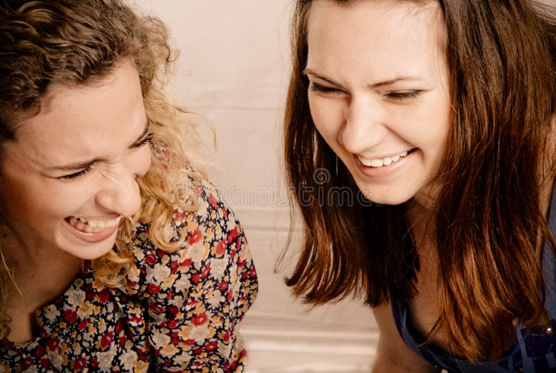 Two girl friends laughing gleefully