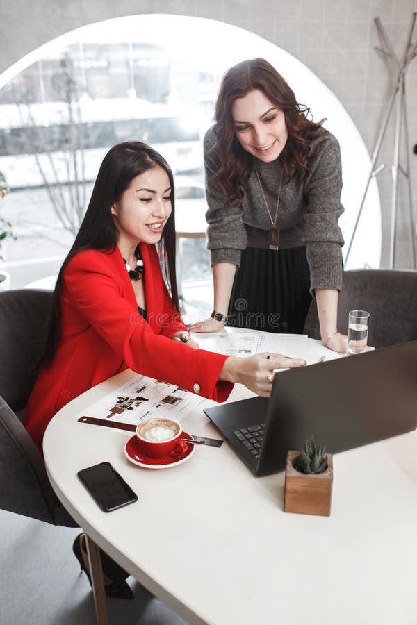 Two girls designers are working with laptop and documentation at the project in the stylish office. Project creation royalty free stock photography Two girls designers are working with laptop and documentation at the project in the stylish office. Project creation royalty free stock photography