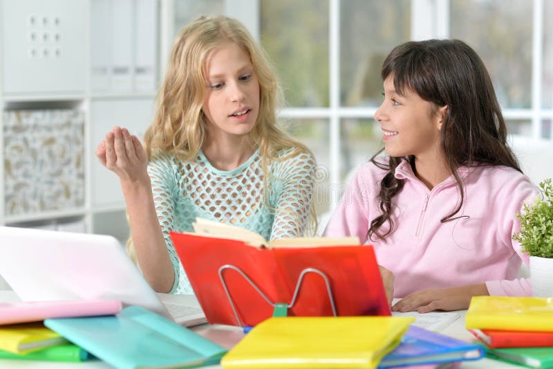 Two girls doing homework stock images