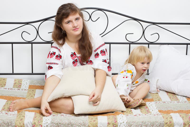 Two girls dressed in Ukrainian on the bed royalty free stock photo Two girls dressed in Ukrainian on the bed royalty free stock photo