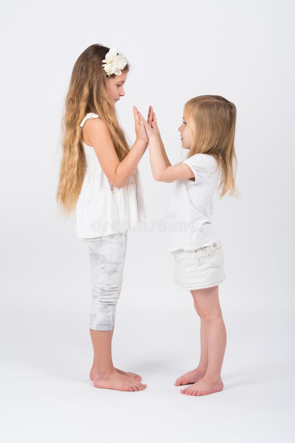 Two girls dressed in white playing stock image