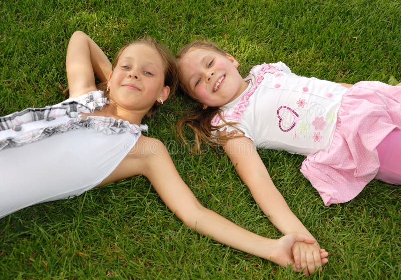 Two Girls Lie On Green Grass Stock Image Image Of Lovely Cheerful