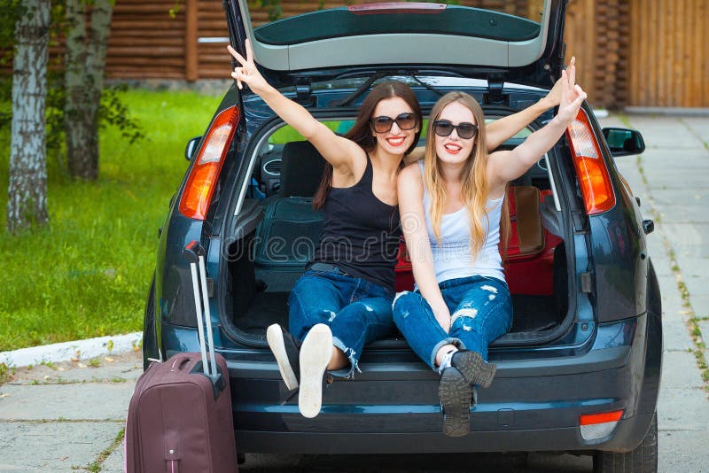 Two girls posing in car