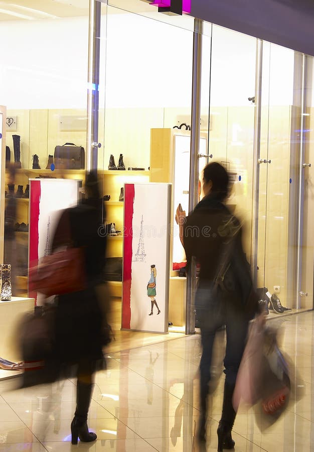 Due ragazze nel centro commerciale vicino ad una vetrina di un negozio.