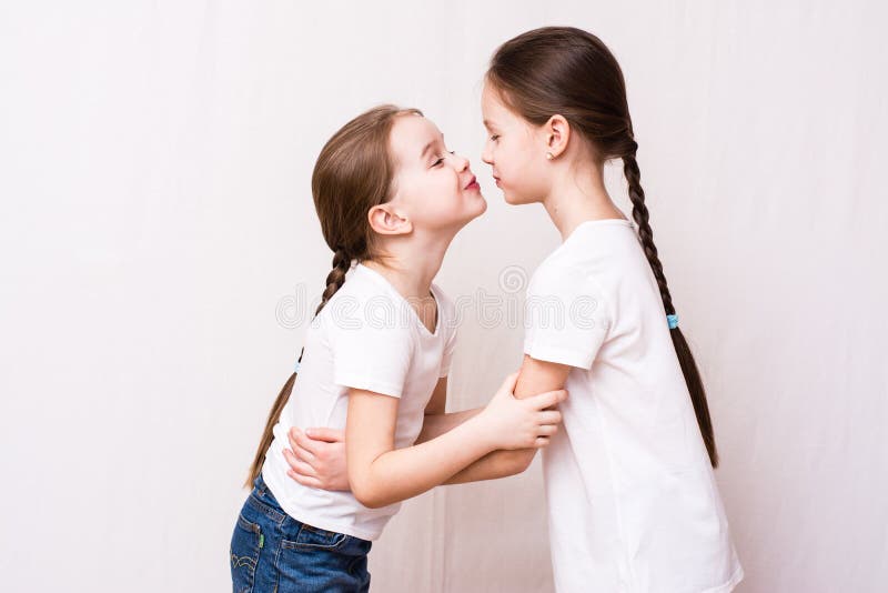 Two girls sisters kiss each other when meeting stock photos.