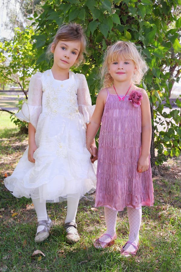 Two girls wearing beautiful dresses holding hands royalty free stock image Two girls wearing beautiful dresses holding hands royalty free stock image