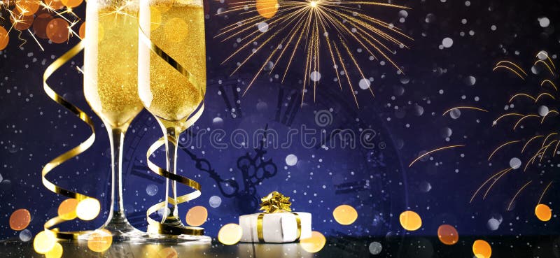 Two glasses of champagne with gold ribbon and gift on dark background with lights and fireworks