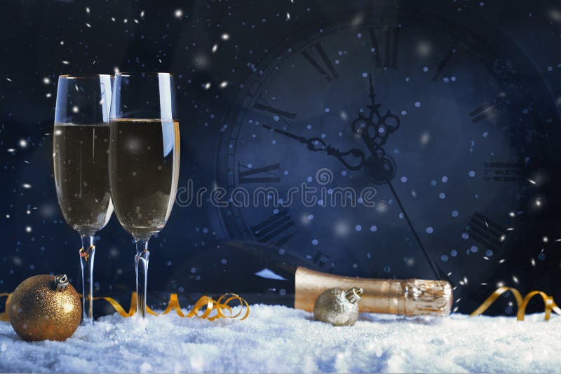 Two glasses of champagne with golden ribbon, star and ball with snow. Night of celebration concept