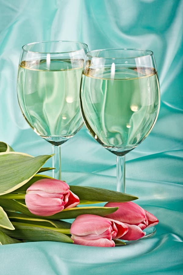 Two glasses of white wine and tulips