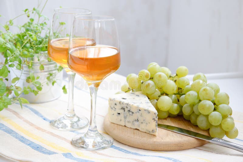 Two glasses of wine, grapes and blue cheese