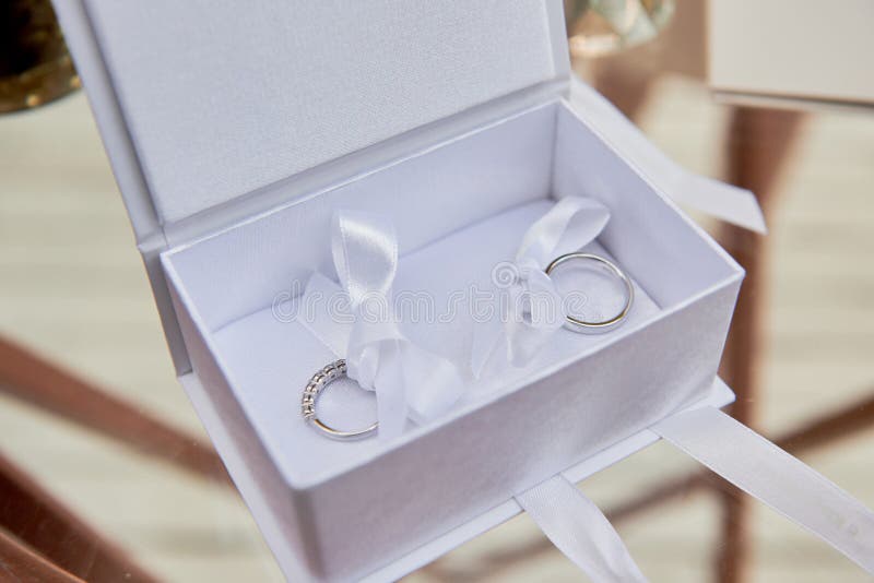 Two Golden Wedding Rings on White Box on Table, Copy Space. Stock Image