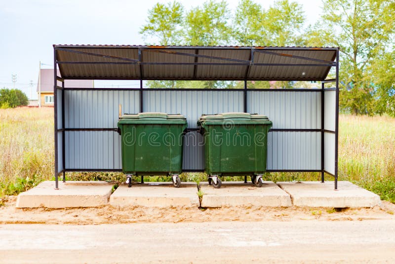 Two Green Dumpsters on the Street Under a Canopy. Garbage Reform in