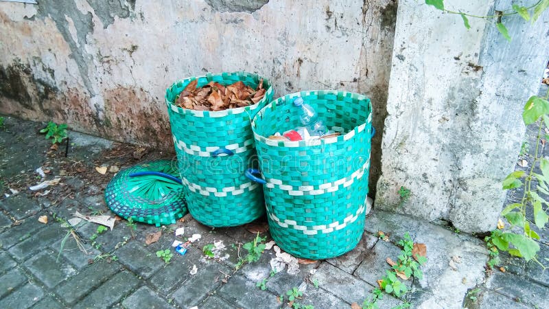 Two green trash bins made of woven plastic stock images