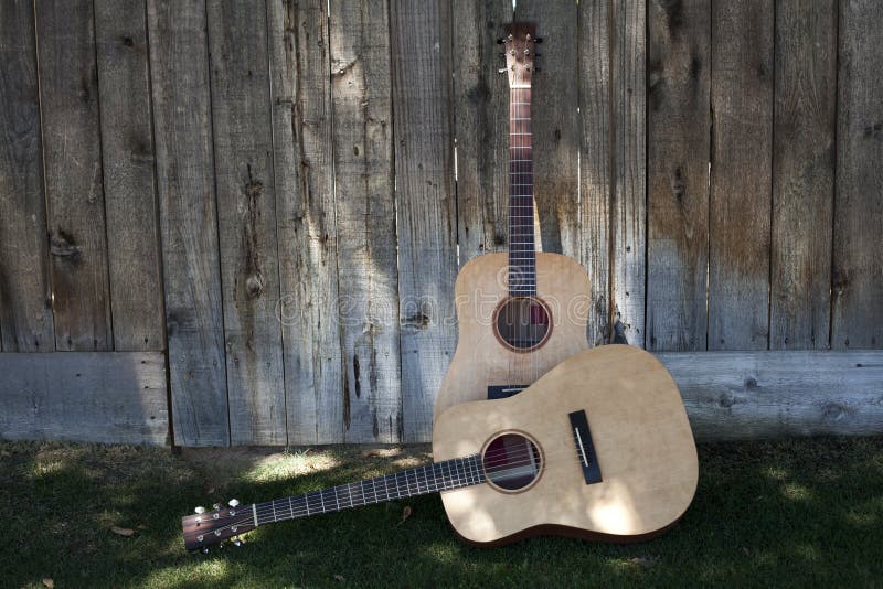 Two Guitars Against a Fence royalty free stock photography