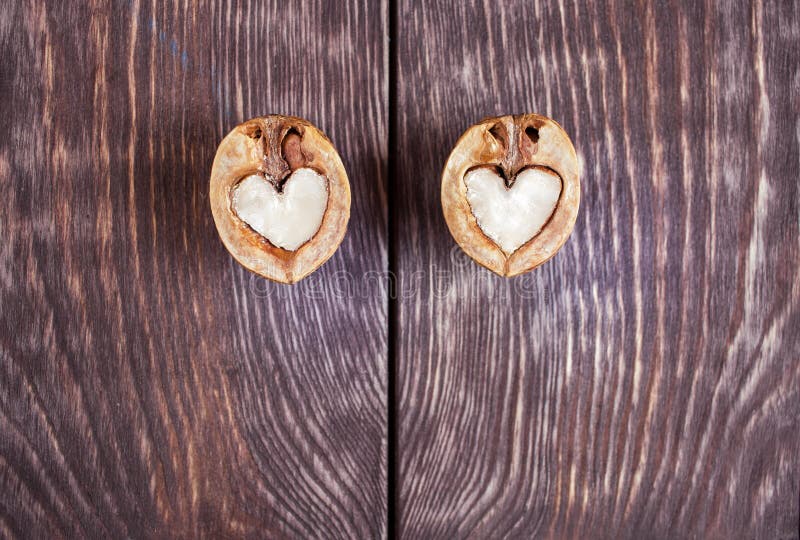 Two halves of walnut in shape of heart are lying on two part of stock photos Two halves of walnut in shape of heart are lying on two part of stock photos