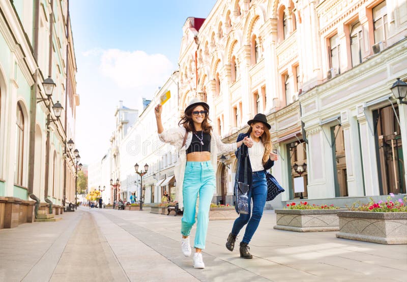 Two happily jumping girls while walking