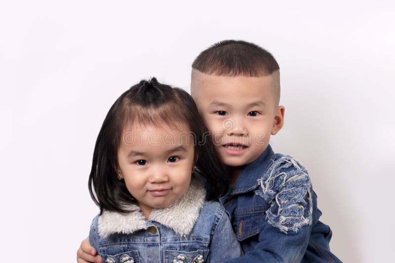 Two happy asian children hugging on a light background royalty free stock image
