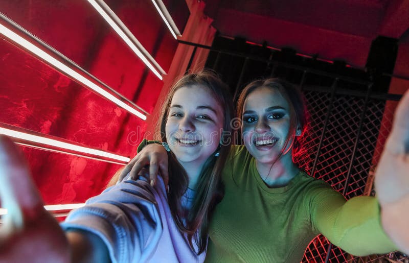 Two happy best female friends young girls at disco party posing for photo