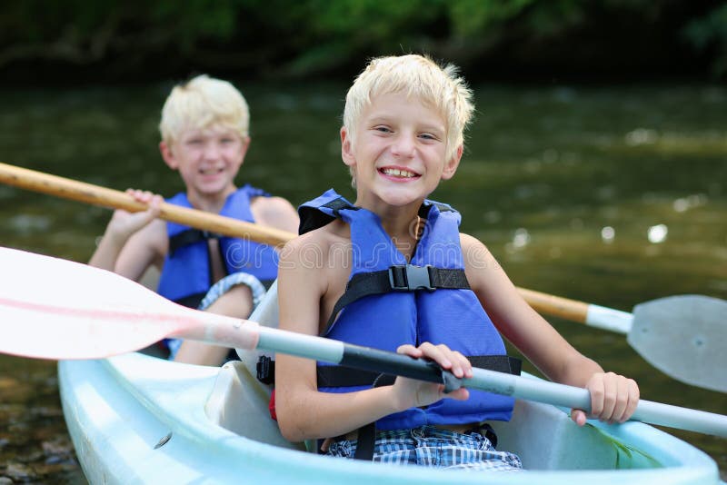 Two happy boys kayaking on the river stock photos Two happy boys kayaking on the river stock photos