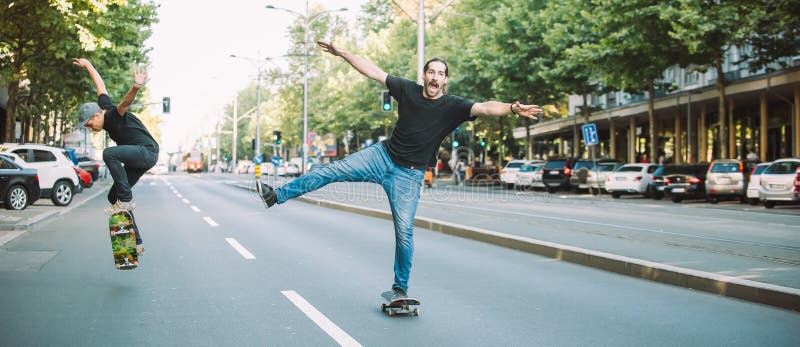 Two happy and funny skaters ride a skateboard in the city street. Close up. Two happy and funny skaters ride a skateboard in the city street. Close up