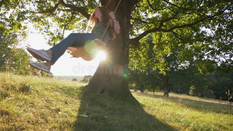 Two happy girls have fun on rope swing - slow motion