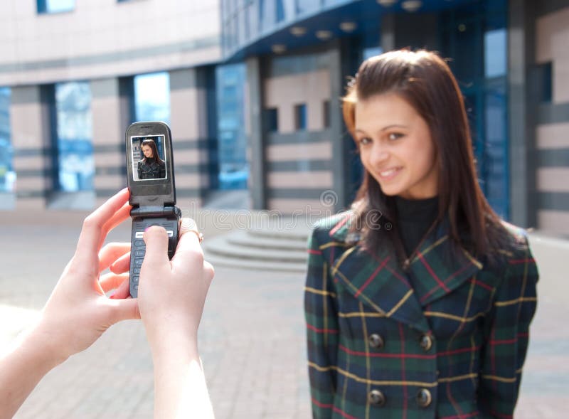 Two happy girls take pictures on a street