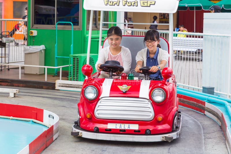 Two Happy Japanese Girls Riding on a Furi Furi GP Car at Tokyo D