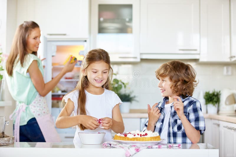 Two happy kids baking cake with red currants royalty free stock photo Two happy kids baking cake with red currants royalty free stock photo
