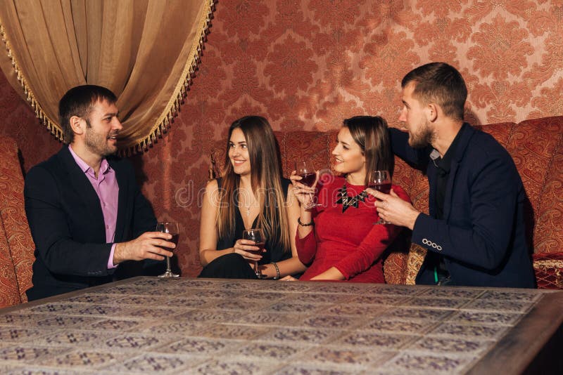 Two happy smiling young couples with champagne at celebration