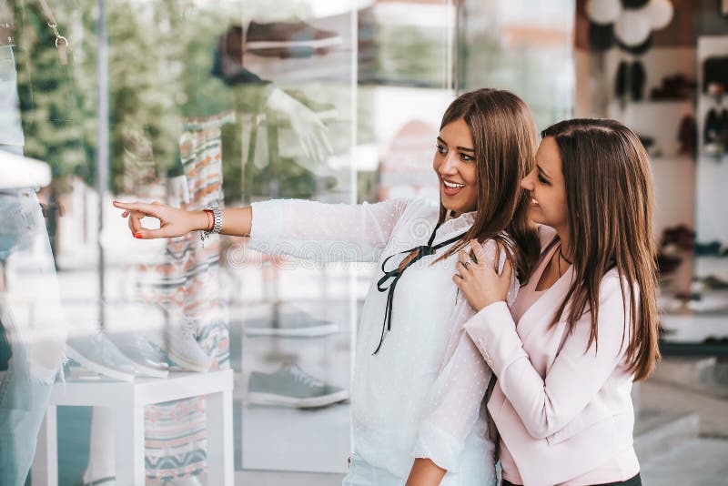 Two Happy women enjoy shopping while pointing finger in the shop window royalty free stock photo Two Happy women enjoy shopping while pointing finger in the shop window royalty free stock photo