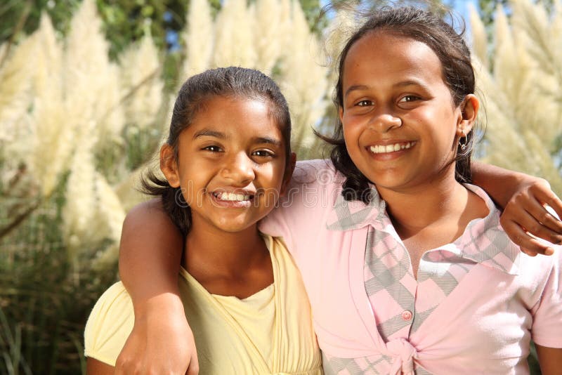 Two happy young school girls in friendship hug