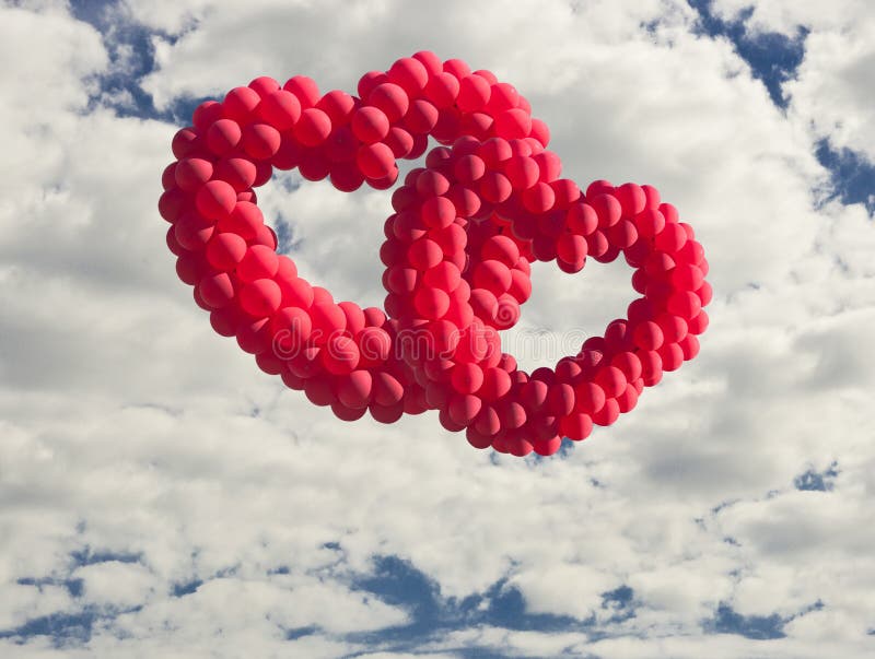 Two heart-shaped baloons in the sky