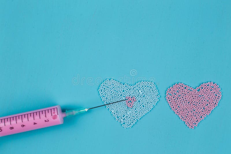 Two hearts of beads and medical syringe, injection, falling in love symbol. Love, feelings and states of mind concept concept