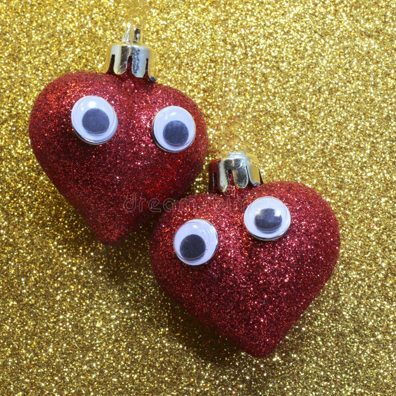Two Hearts with Eyes in the Golden Background Glitter Stock Image