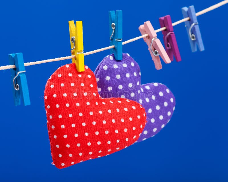 Two hearts hanging on a clothesline with clothespins